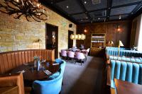 um restaurante com mesas e cadeiras e uma parede de tijolos em Rooms at the Saint em St Andrews