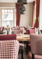Un restaurante con mesas y sillas y una ventana. en Hotel Hessenhof, en Winterberg