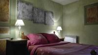 a bedroom with a bed with a purple bedspread and two lamps at Gite de charme au coeur de la Bourgogne in Santigny
