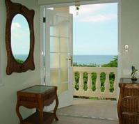 an open door to a balcony with a view of the ocean at Dos Angeles del Mar Bed and Breakfast in Rincon