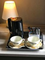 a tray with two cups and a coffee maker on a table at Hôtel des Chazes in Saint-Jacques-des-Blats