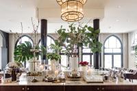 Una mesa con velas y plantas en una habitación con ventanas. en Nimb Hotel, en Copenhague