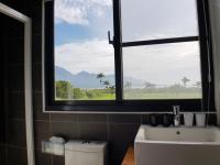 a bathroom with a window and a sink and a toilet at Taitung Jia Lulan Tribal in Taitung City