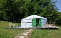 a yurt with a table and chairs in a field at Yourtes Olachat proche Annecy in Faverges