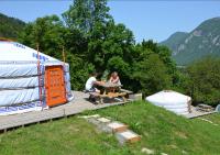 two people sitting at a picnic table next to an rv at Yourtes Olachat proche Annecy in Faverges