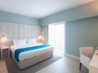 a bedroom with a large bed and a window at Lutecia Smart Design Hotel in Lisbon