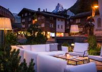 a living room with a white couch and a table at Grand Hotel Zermatterhof in Zermatt