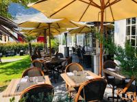 an outdoor restaurant with tables and chairs and umbrellas at Hôtel-Restaurant La Mascotte in La Baule