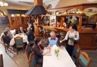 um grupo de pessoas sentadas às mesas de um restaurante em Landhotel Rittersgrün em Breitenbrunn