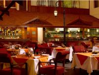 a restaurant with tables and chairs and a bar at The Paul Bangalore in Bangalore