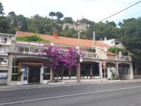 ein Gebäude mit lila Blumen an der Seite einer Straße in der Unterkunft Apartment Astoria in Krilo