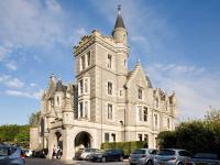 a building with cars parked in front of it at Ardoe House Hotel &amp; Spa in Aberdeen