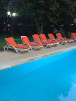 a row of red lounge chairs next to a swimming pool at Suite Laguna Otel in Antalya