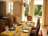 a dining room with a table and chairs and a large window at Beautiful country house with enclosed garden in green surroundings in Burgundy in Bouix