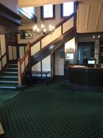 un vestíbulo con escalera y un bar en un edificio en The Kamo Hotel, en Whangarei