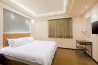 ein Hotelzimmer mit einem Bett und einem Schreibtisch in der Unterkunft Bitan Hotel in Xindian