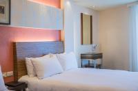 ein Hotelzimmer mit einem Bett mit weißen Kissen in der Unterkunft Bitan Hotel in Xindian