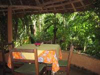 KikambalaBoko Boko Guesthouse and Porini Restaurant的一张桌子,上面有两把椅子和一碗鲜花