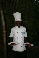 KikambalaBoko Boko Guesthouse and Porini Restaurant的一位厨师拿着两盘食物