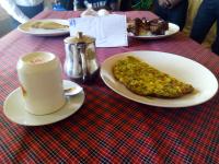 a table with plates of food on a red table at Mbunga Community Tourism Campsite in Kasese