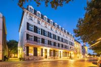 a large white building on a street at night at Hotel Monastère Maastricht in Maastricht