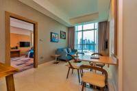 a room with a table and chairs and a living room at Canal Central Hotel Business Bay in Dubai
