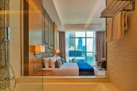 a bedroom with a bed and a view of a city at Canal Central Hotel Business Bay in Dubai