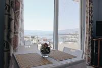 una mesa con un jarrón en una mesa con una ventana en Elti Apartment, en Sarandë