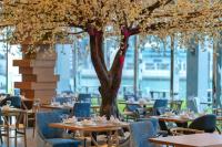a restaurant with tables and chairs and a tree at Canal Central Hotel Business Bay in Dubai