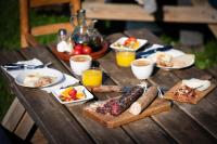 einen Holztisch mit Teller mit Speisen und Getränken in der Unterkunft Casa Rural Mas Garganta in La Pinya