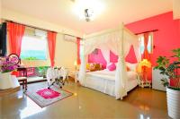 a bedroom with a canopy bed and pink walls at Happy Orange Homestay in Dongshan