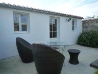 a table and chairs in front of a white house at Chambres d&#39;hôtes - Chez Stephane in L&#39;Ile d&#39;Yeu