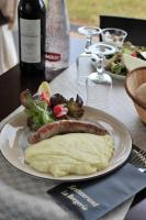 ein Teller mit einer Wurst, einem Salat und einer Flasche Wein in der Unterkunft The Originals Access, Hôtel Millau Sud in LʼHospitalet-du-Larzac