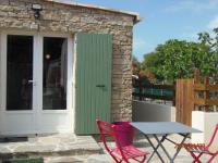 a patio with a table and chairs and a door at mini villa studio que du bonheur in Calenzana