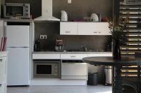 a kitchen with white appliances and a small table at Gîte d&#39;Anne et Ulysse in Sept-Frères