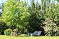 two chairs and a bike sitting in the grass at Gîte d&#39;Anne et Ulysse in Sept-Frères