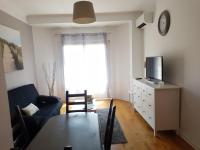 a living room with a table and a couch and a tv at le mauritania in Sainte-Maxime