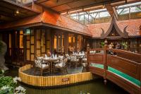 a restaurant with tables and chairs in a building at Mövenpick Grand Al Bustan in Dubai
