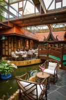 a restaurant with a pond in the middle of a building at Mövenpick Grand Al Bustan in Dubai