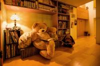 a large teddy bear sitting on a couch in a room at Happiness B&amp;B in Luodong