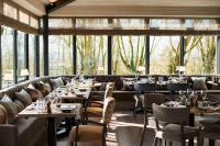 a restaurant with tables and chairs and large windows at The Fish Hotel in Broadway