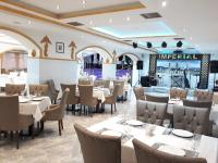 a restaurant with tables and chairs and a bar at Grand Georgian Palace in Batumi