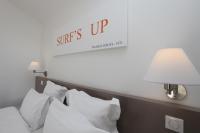 a bed with white pillows and a sign that reads sun sets up at Hotel 202 in Hossegor