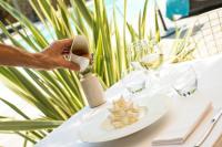una persona tomando una fotografía de un plato sobre una mesa en Hôtel La Dimora & Spa, en Saint-Florent