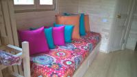 a bed with colorful pillows in a small room at L&#39;Escale des Châteaux de la Loire in Angé