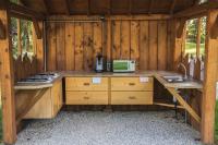 a kitchen in a log cabin with a sink and a microwave at L&#39;Escale des Châteaux de la Loire in Angé