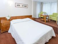 ein Hotelzimmer mit einem Bett und einem Tisch und Stühlen in der Unterkunft Willa Biala Lilia Old Town in Danzig