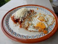an orange and white plate with breakfast food on it at Casa Arcoiris Zihuatanejo B&B in Zihuatanejo