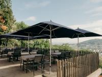 een restaurant met tafels en stoelen onder een parasol bij Bienenberg - Das Genusshotel im Grünen - Liestal in Liestal