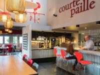 ランスにあるibis Reims Tinqueuxの店のカウンターに座る男